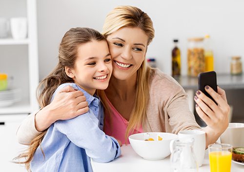 Mother and daughter having their selfie while in the dining room